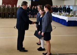 Sekretarz Stanu w Ministerstwie Spraw Wewnętrznych i Administracji Jarosław Zieliński wręczający nagrodę wyróżnionej dziewczynce z konkursu