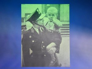 Fotografia przedwojennej policjantki trzymającej dziecko.