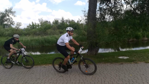 Polski policjant jedzie rowerem, za nim jedzie policjant ukraiński.