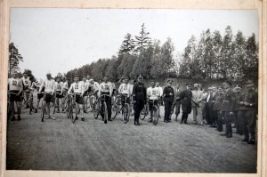 Policjanci okresu dwudziestolecia międzywojennego przygotowują się do startu w wyścigach rowerowych.