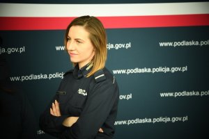 Policjantka na tle ścianki KWP w Białymstoku.