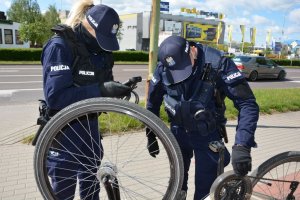 Policjanci sprawdzają numery seryjne roweru.