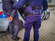 policjant z zatrzymanym przy samochodzie