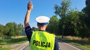 policjant stojący tyłem z ręką w górze