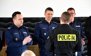 trzech policjantów ubranych w granatowe mundury, wręczający nagrodę zwycięzcy turnieju