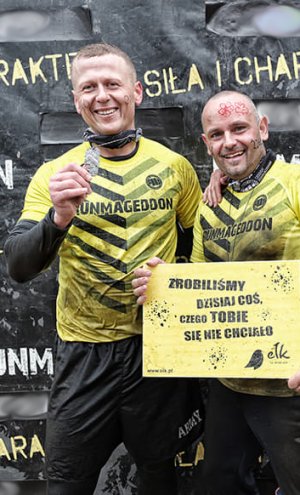 Zdjęcie w kolorze. Na pierwszym planie dwóch policjantów na mecie biegu Runmageddon w Ełku.