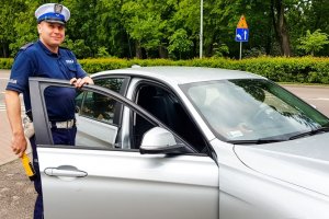 policjant w mundurze przy samochodzie