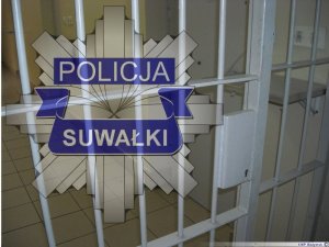 zdjęcie krat w celi i napis &quot;policja Suwałki&quot;