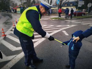 policjant ruchu drogowego, który przekazuje odblask małemu chłopcu