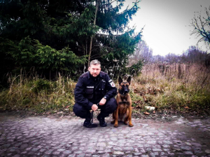 Policjant razem ze swoim psem służbowym.
