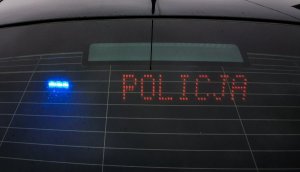 Tylny panel nieoznakowanego radiowozu z napisem policja.