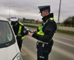 umundurowany policjant ruchu drogowego stojący przy samochodzie