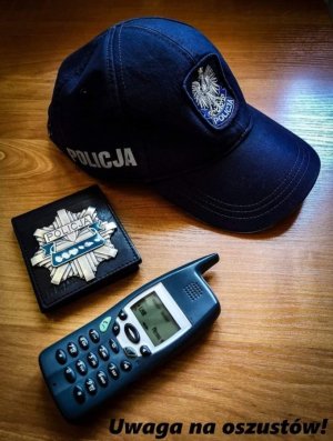 na blacie leży czapka z napisem policja telefon i rozeta z napisem policja