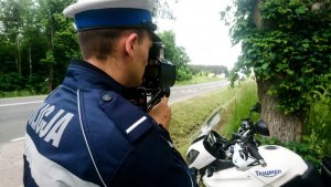 policjant ruchu drogowego dokonuje pomiaru prędkości