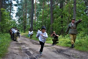 dzieci w lesie; jedni biegną, inni kibicują