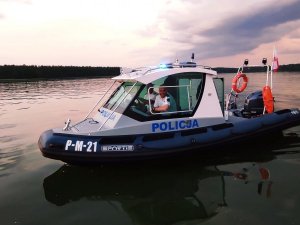 Policjanci z patrolu wodnego w policyjnej łodzi na jeziorze.