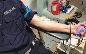 ręka mężczyzny w mundurze z wbitą igła do pobierania krwi
