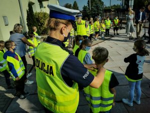 Policjantki Ruchu Drogowego z Komendy Wojewódzkiej Policji w białymstoku oraz Komendy Miejskiej Policji w Białymstoku na spotkaniu z dziećmi. Policjantki rozdają dzieciom odblaskowe żółte kamizelki