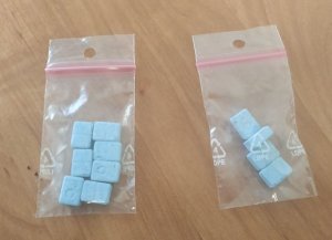 woreczki foliowe na biurku; w nich niebieskie tabletki