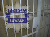 Gwiazda policyjna z napisem policja Suwałki a w tle kraty.