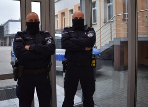 dwóch policjantów stoi bok siebie w budynku