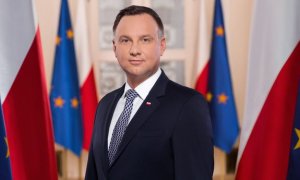 Prezydent na tle flag Polski i Unii Europejskiej