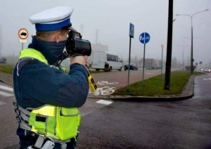policjant trzyma urządzenie do mierzenia prędkości