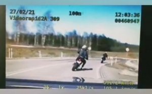 Widok na monitor z filmem na którym widać jadącego motocyklistę.