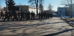 Grupa policjantów biegnie po placu.