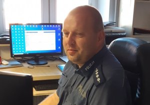 policjant przy monitorze komputera wewnątrz jednostki
