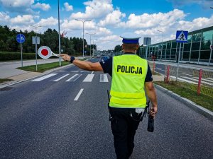 policjant na drodze w dłoni trzyma tarczę stop