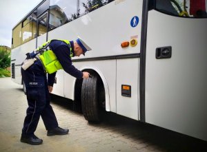 Policjant kontroluje autobus.