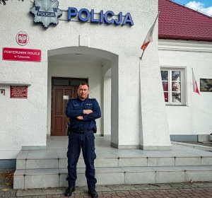 Policjant stoi przy budynku
