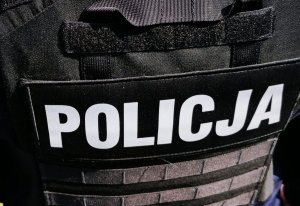 biały napis policja na czarnym elemencie munduru