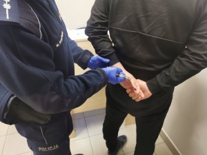 policjant zakładający kajdanki mężczyźnie