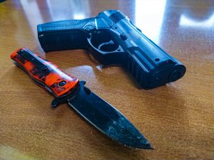 nóż i pistolet na blacie stołu