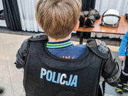 chłopiec w kamizelce z napisem policja