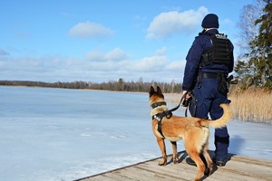 policjant z psem nad jeziorem