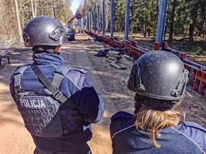 dwoje policjantów przy budowanym płocie granicznym