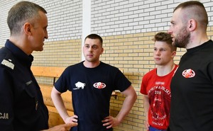 czterech mężczyzn rozmawia z sobą na sali gimnastycznej