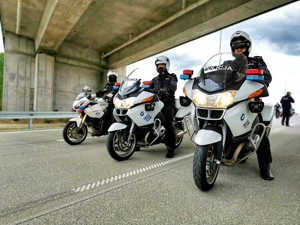 Funkcjonariusze jeżdżą motocyklami po drodze