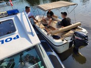 motorówka przy policyjnej łodzi na motorówce dwie osoby