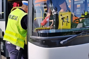 policjant podczas kontroli autobusu