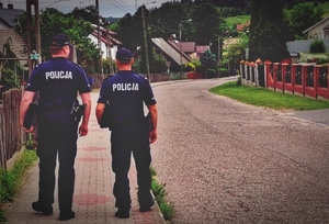 Dwóch policjantów idzie chodnikiem