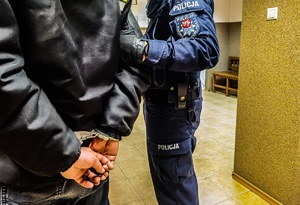 Policjant trzyma zatrzymanego