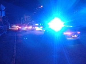 samochody policyjne na ulicy widać włączone światła uprzywilejowania