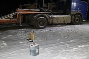 Ciężarówka zaparkowana na śniegu a obok plastikowe pojemniki