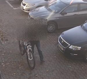 zdjęcie z monitoringu, osoba prowadzi rower