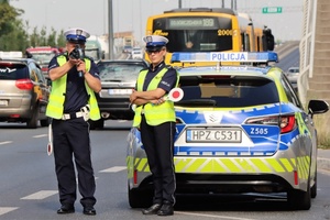policjanci przy samochodzie na drodze