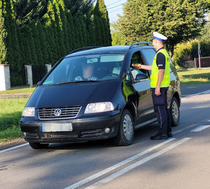 policjant na drodze bada trzeźwość kierowcy